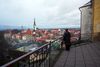 A visitor looks out over buildings towards St.Olaf's church in the old town area of Tallinn.